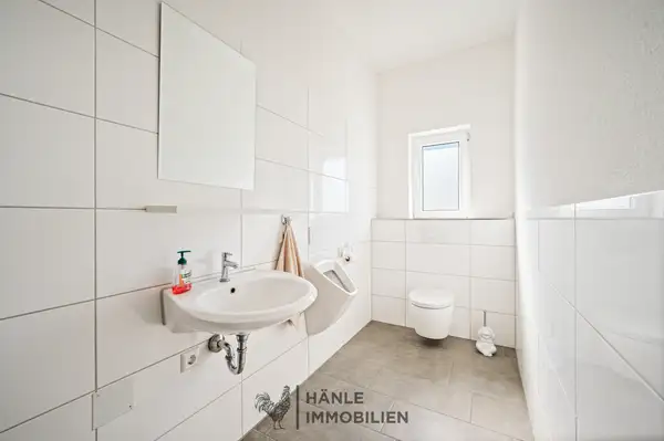 Modern ausgestatteter Sanitärbereich mit WC und Urinal